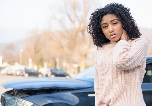 A women who has been injured in a car accident, rubbing her neck